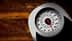 Analog weight scale featuring a round dial with a red pointer and numerical markings. - Olive Oil Times