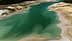 Aerial view of a calm water body with varying shades of green and blue. - Olive Oil Times