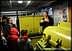 A man explaining olive oil production to a group of people in a mill setting. - Olive Oil Times