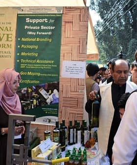 Exhibition booth featuring olive oil products and promotional materials at an event. - Olive Oil Times