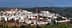 Panoramic view of Montoro, a village with white buildings and a prominent clock tower in the background. - Olive Oil Times