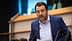 A man in a blue suit speaking at a podium with a microphone in a formal setting. - Olive Oil Times