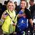 Two women holding glasses at a social event, one wearing a yellow vest and the other in a floral dress. - Olive Oil Times
