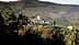 A villa with a tower situated on a hillside in Tuscany, surrounded by trees and rolling hills. - Olive Oil Times